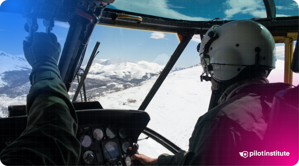 Two pilots in a helicopter cockpit fly over a snowy mountain landscape, with one pilot gripping the cyclic control.