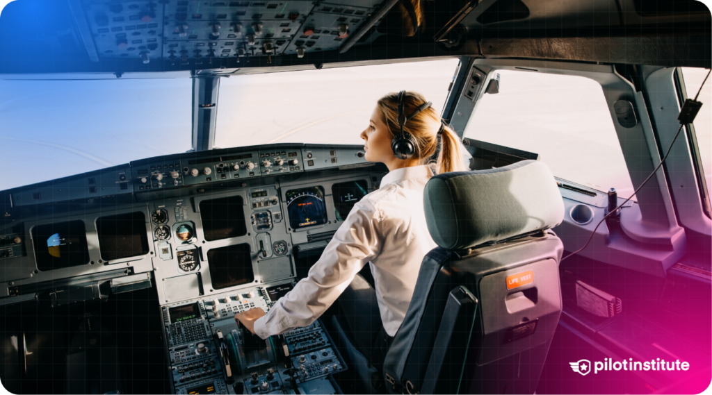 Female pilot in a modern commercial aircraft cockpit operating the controls.