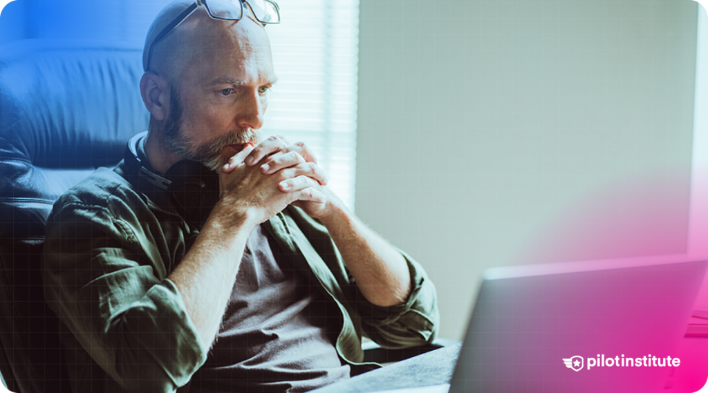 A photo of a man staring at his laptop monitor contemplating.