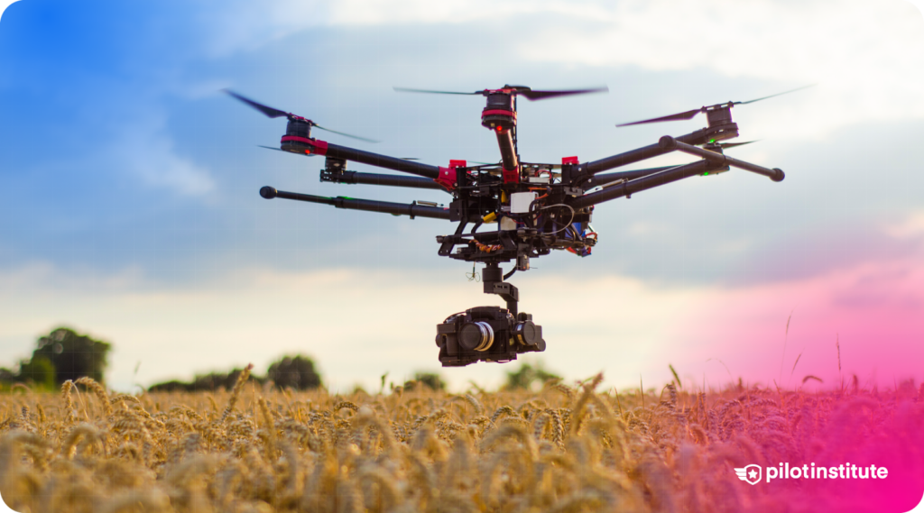 A professional drone with a mounted camera flying over a wheat field, likely used for aerial photography or agricultural mapping.